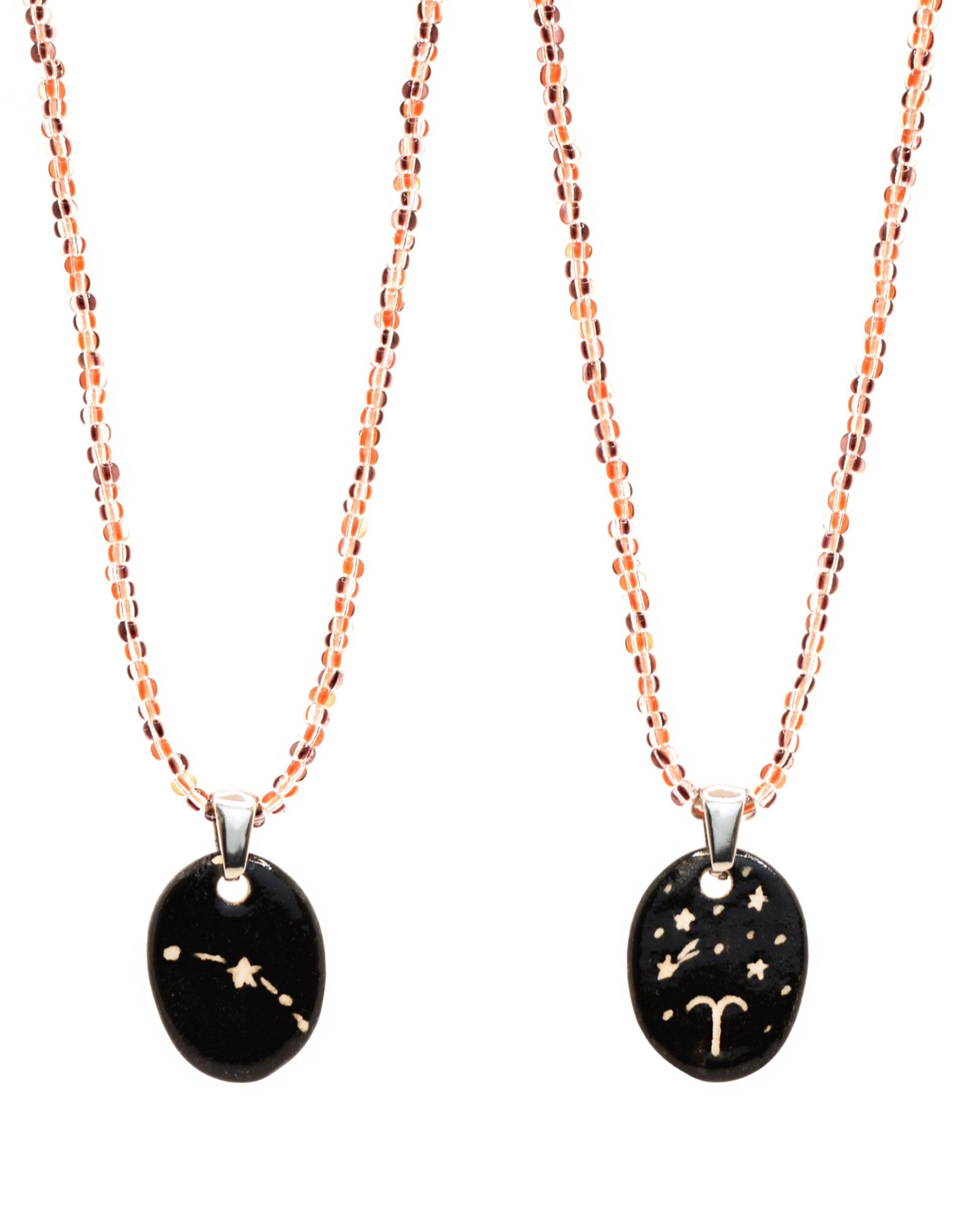 Colar elegante com pendente dupla-face esculpido em cerâmica, retratando a constelação de Carneiro, complementado por missangas listradas em tons castanhos para um toque de estilo e charme distintos.