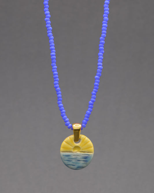 Colar com pendente de sol nascente, símbolo de novos começos e energia positiva para iluminar seu dia.