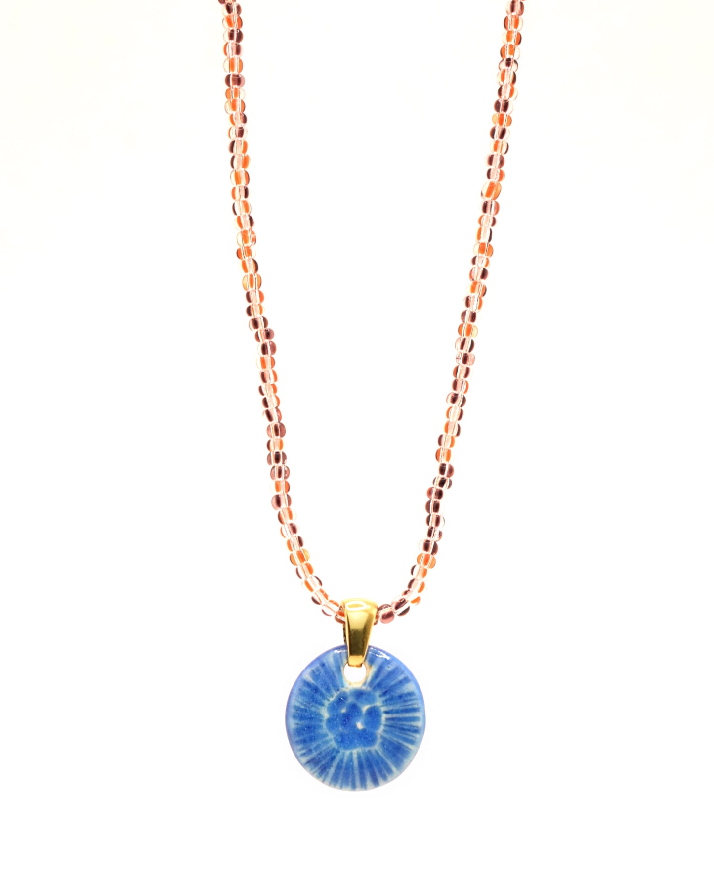 Colar encantador com missangas de vidro listradas castanhas e pendente de cerâmica azul, inspirado numa flor do mar. A fusão de tons terrosos e a delicadeza das missangas cria uma peça única, conferindo um toque de elegância natural ao seu visual.