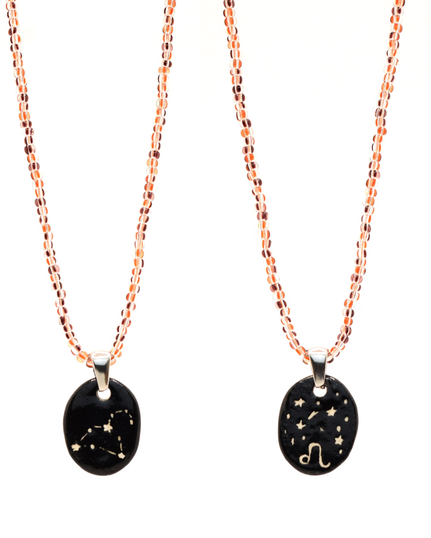 Colar elegante com pendente dupla-face esculpido em cerâmica, retratando a constelação de Leão, complementado por missangas listradas em tons castanhos para um toque de estilo e charme distintos.