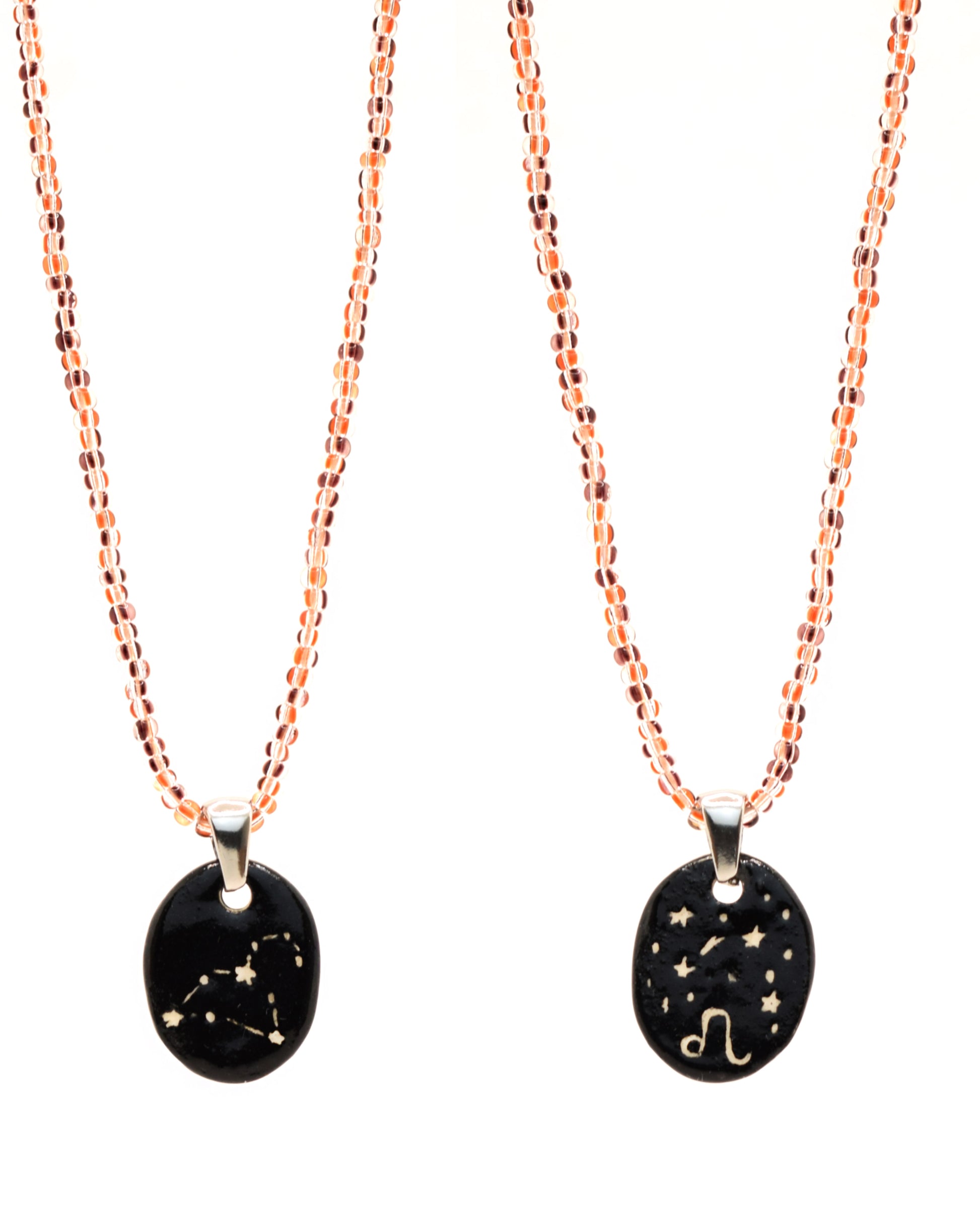 Colar elegante com pendente dupla-face esculpido em cerâmica, retratando a constelação de Leão, complementado por missangas listradas em tons castanhos para um toque de estilo e charme distintos.