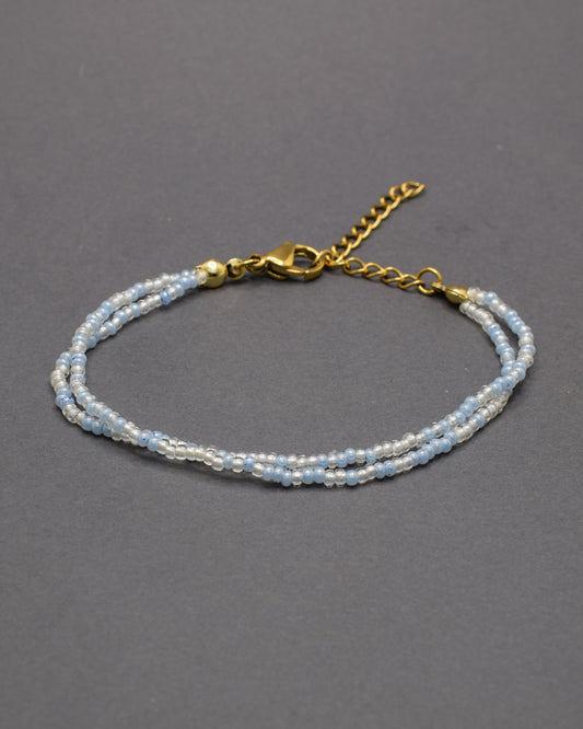 Pulseira dupla com missangas azul claro em mix suave. Peça artesanal e luminosa, ideal para complementar visuais leves e contemporâneos.