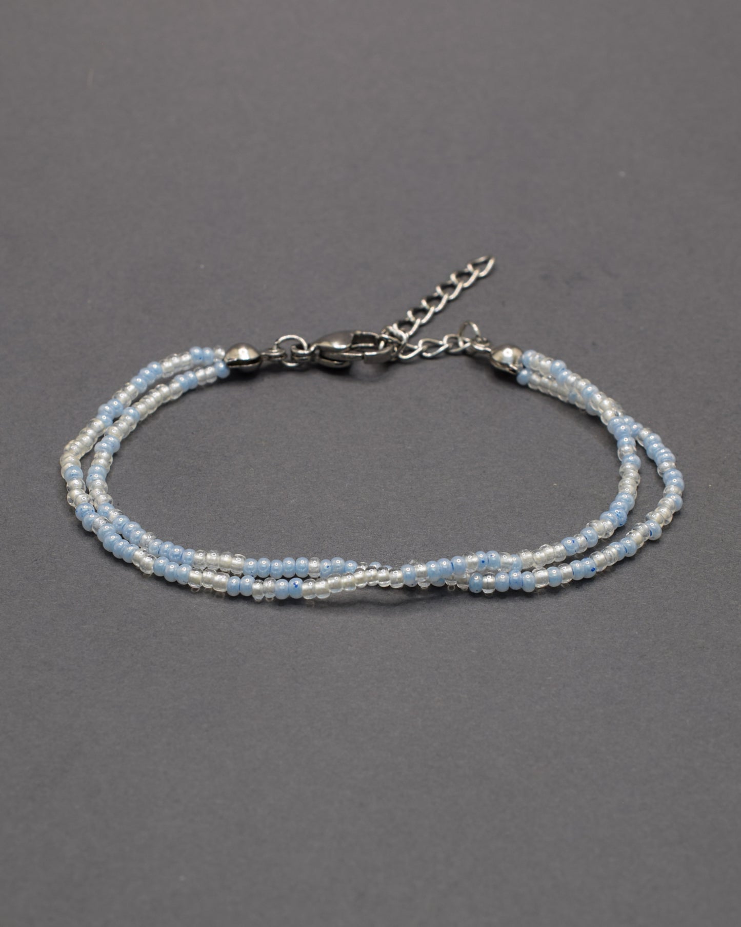 Pulseira dupla com missangas azul claro em mix suave. Peça artesanal e luminosa, ideal para complementar visuais leves e contemporâneos.