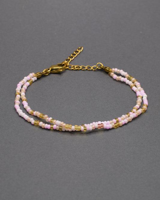 Pulseira dupla de missangas em tons de rosa e dourado, combinando delicadeza e estilo num design vibrante e elegante.