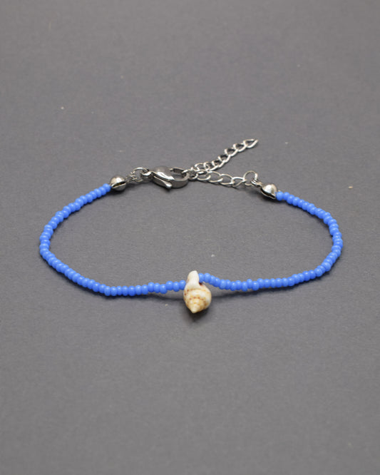 Pulseira com búzio natural e missangas de vidro azul néon, marcante e moderna, adiciona um toque distintivo e cheio de vida ao teu estilo.