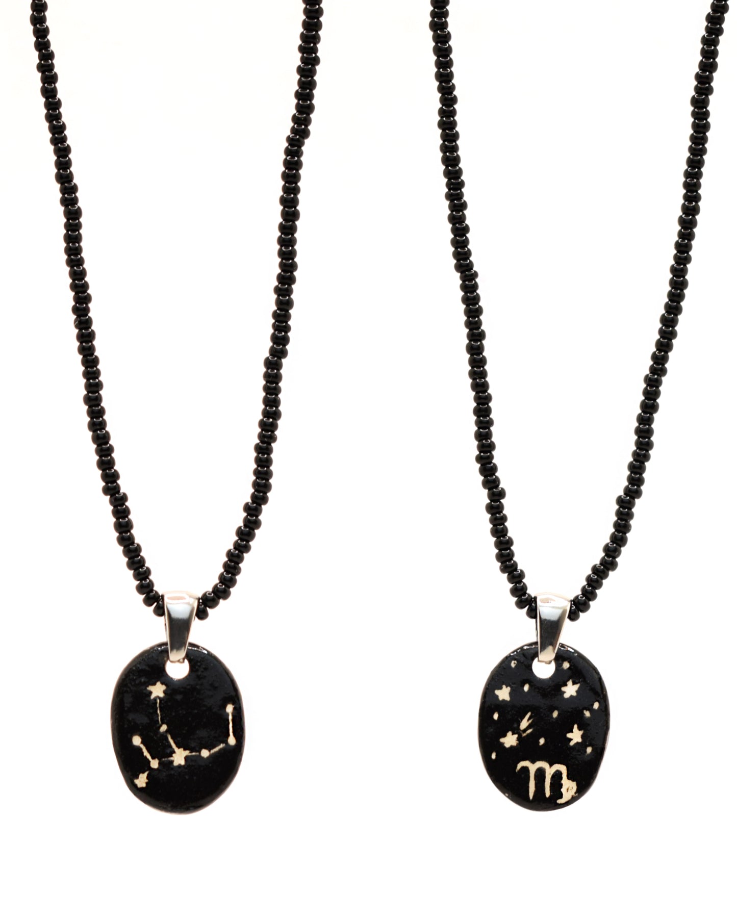 Colar elegante com pendente de cerâmica dupla-face representando a constelação Virgem, adornado com missangas de vidro pretas para um toque sofisticado e misterioso.