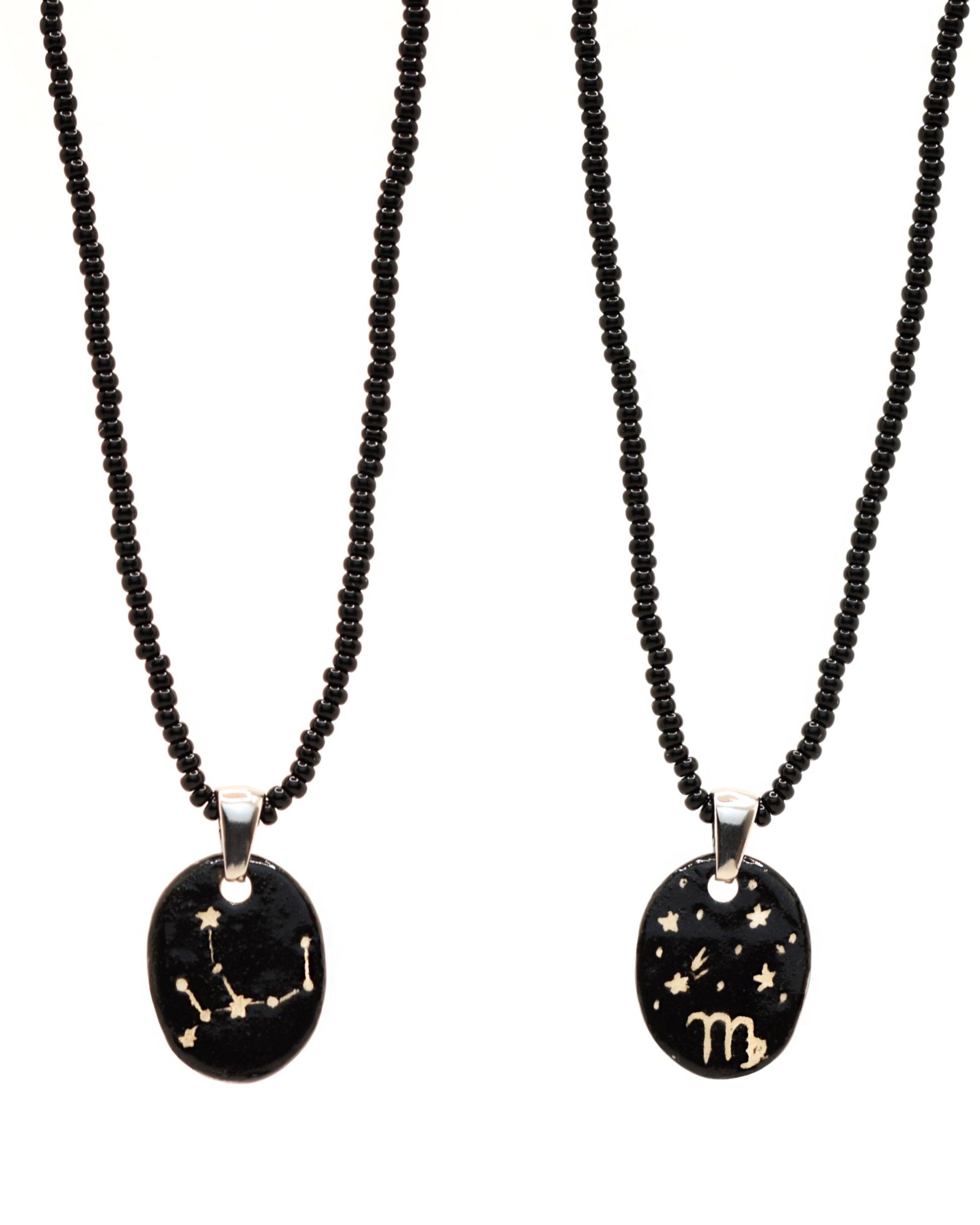 Colar elegante com pendente de cerâmica dupla-face representando a constelação Virgem, adornado com missangas de vidro pretas para um toque sofisticado e misterioso.