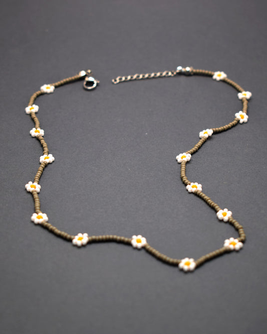 Adicione um toque de elegância e frescor ao seu visual com o nosso deslumbrante Colar de Missangas Cinzentas com Flores Brancas. Este colar exclusivo é artesanalmente confecionado com missangas de alta qualidade, formando um design harmonioso e delicado.