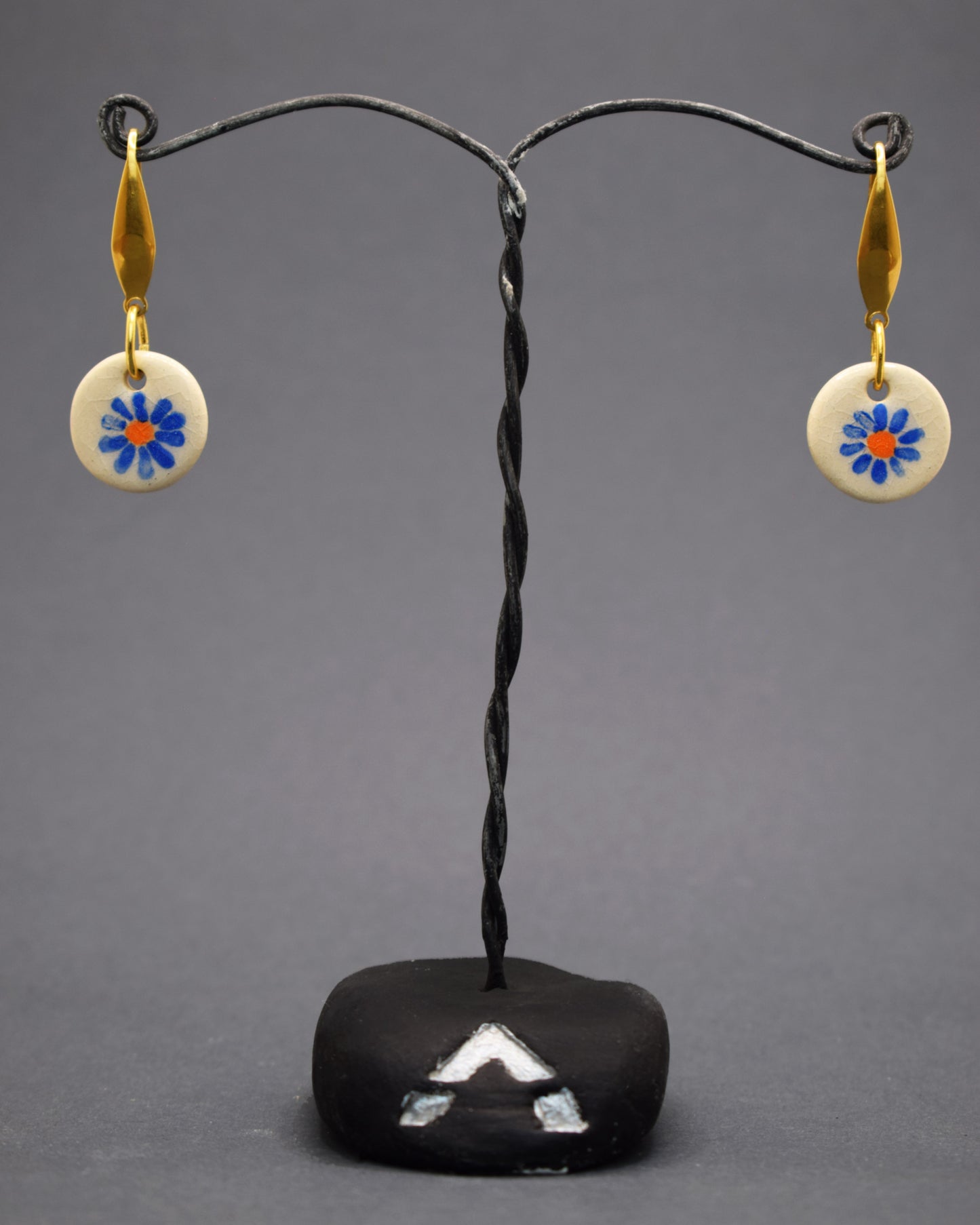 Renove o seu estilo com brincos de aço inox dourado hipoalergénico. Pendentes de cerâmica com margarida azul pintada à mão capturam a beleza artística e serenidade da natureza, ideal para quem busca elegância e originalidade.