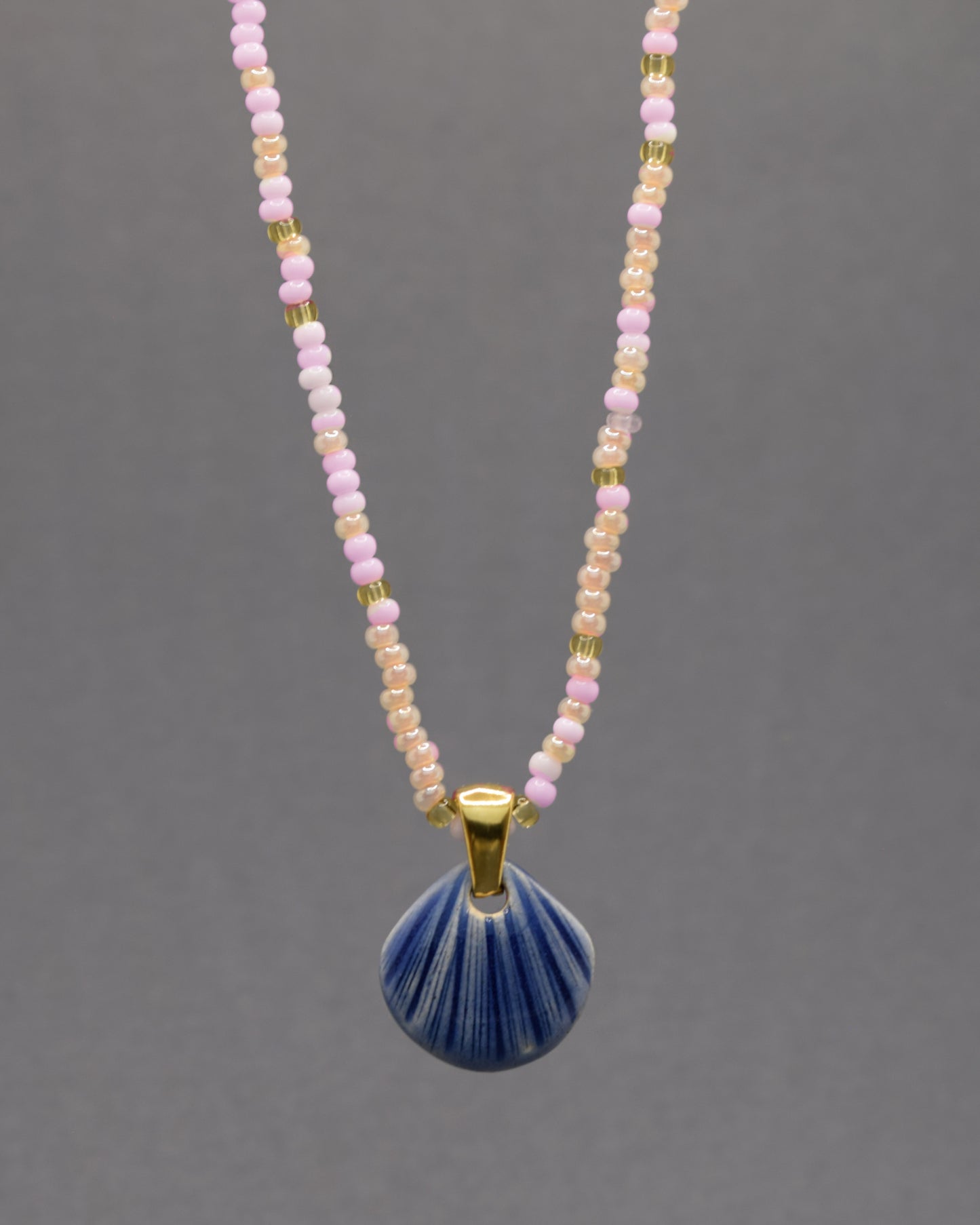 Colar artesanal com pendente de concha em cerâmica azul escuro, inspirado no mar e na serenidade. Elegante e versátil para qualquer ocasião.
