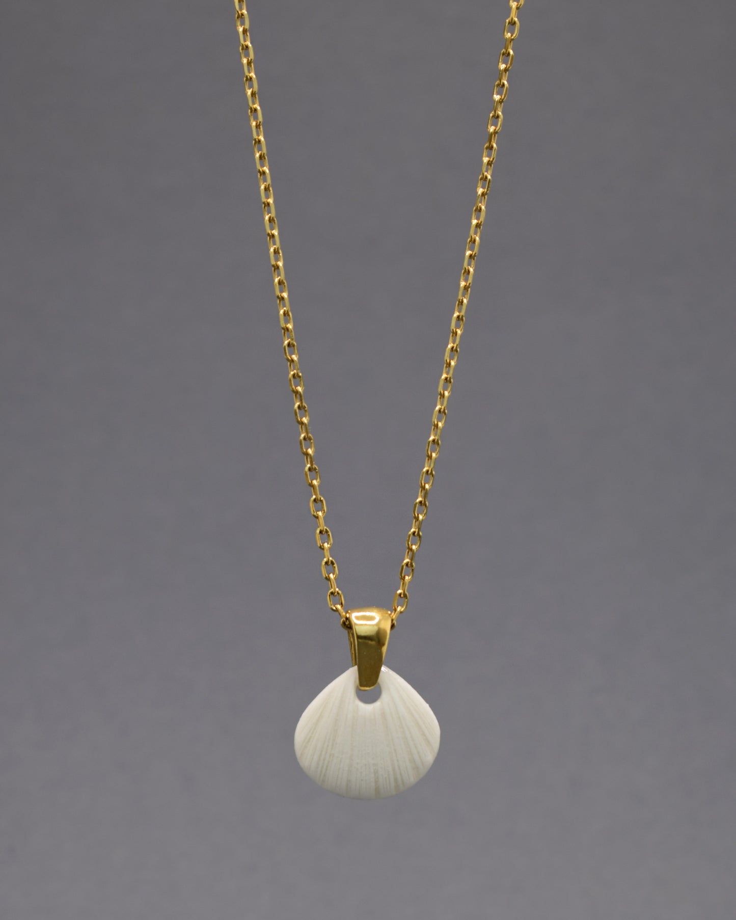 Colar com pendente de porcelana em forma de concha. Peça delicada, feita à mão, ideal para amantes do mar e do design artesanal.