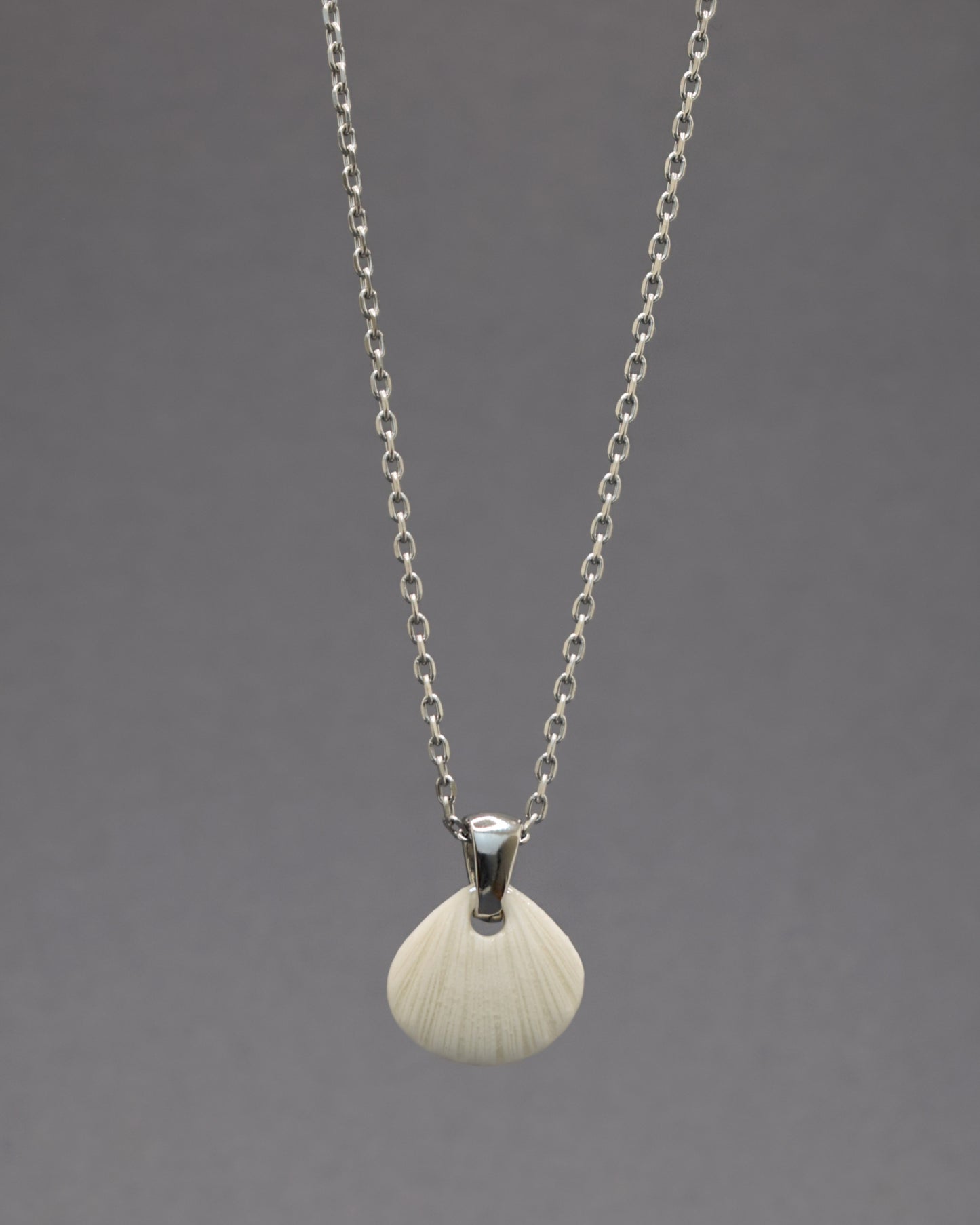 Colar com pendente de porcelana em forma de concha. Peça delicada, feita à mão, ideal para amantes do mar e do design artesanal.