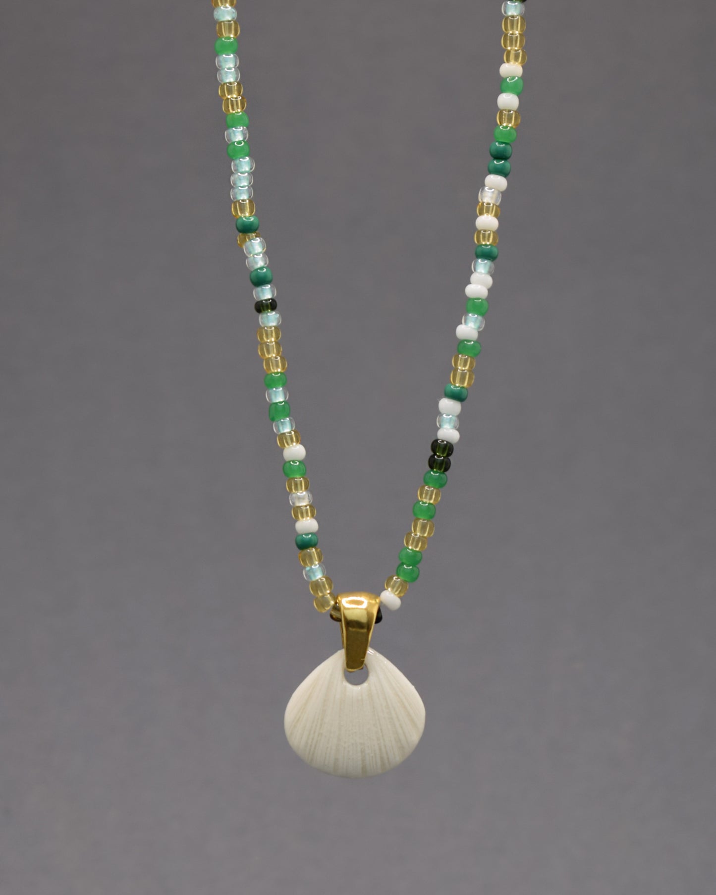 Colar com pendente de porcelana em forma de concha. Peça delicada, feita à mão, ideal para amantes do mar e do design artesanal.