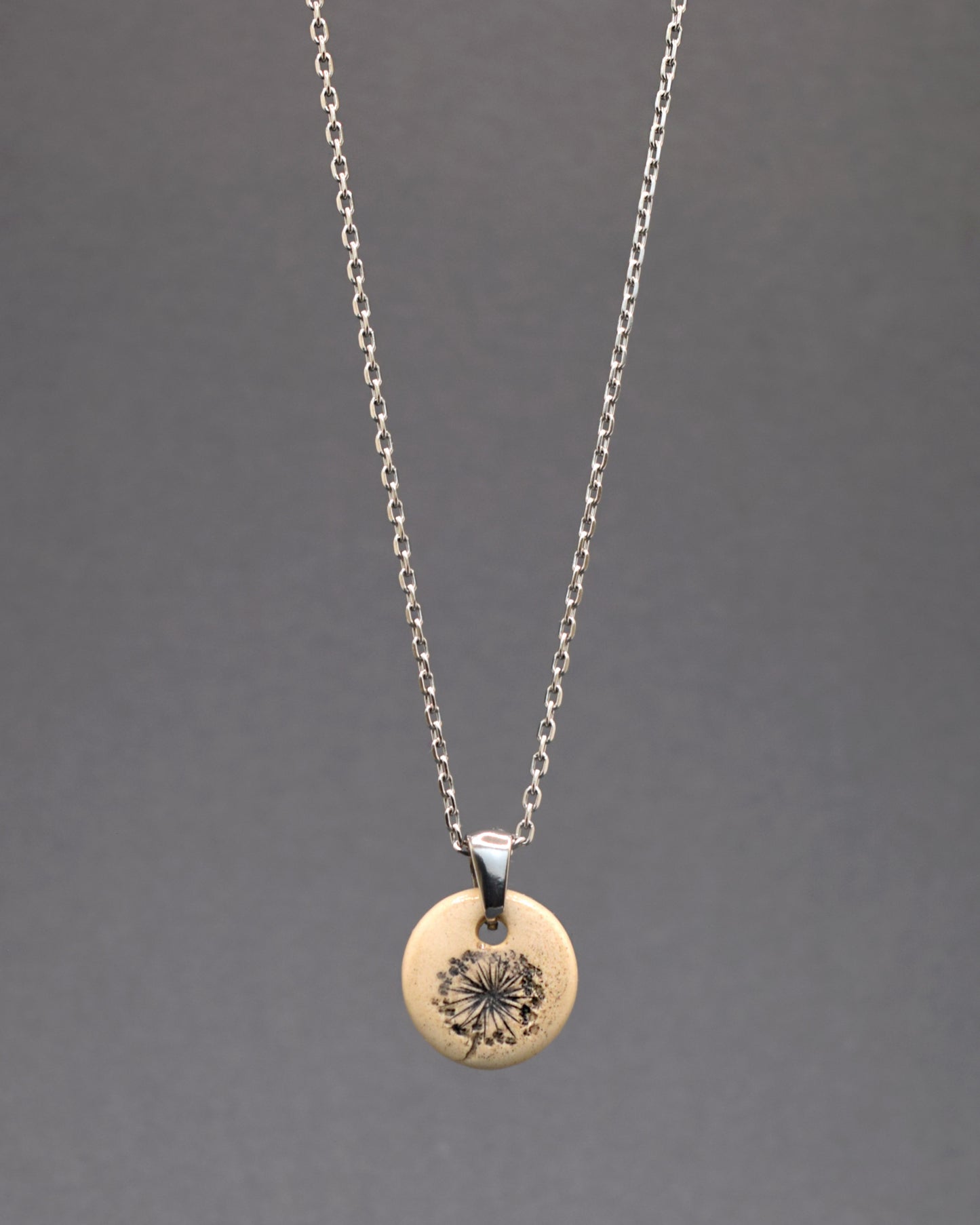 Este exclusivo colar em aço inoxidável, com um pendente de cerâmica feito à mão, destaca-se pela elegância do desenho das plumas de dente de leão, evocando a leveza e a beleza da natureza. Perfeito para quem aprecia detalhes delicados e significativos, este acessório é uma ode à simplicidade e ao encanto natural, prometendo agregar um toque especial a qualquer visual.