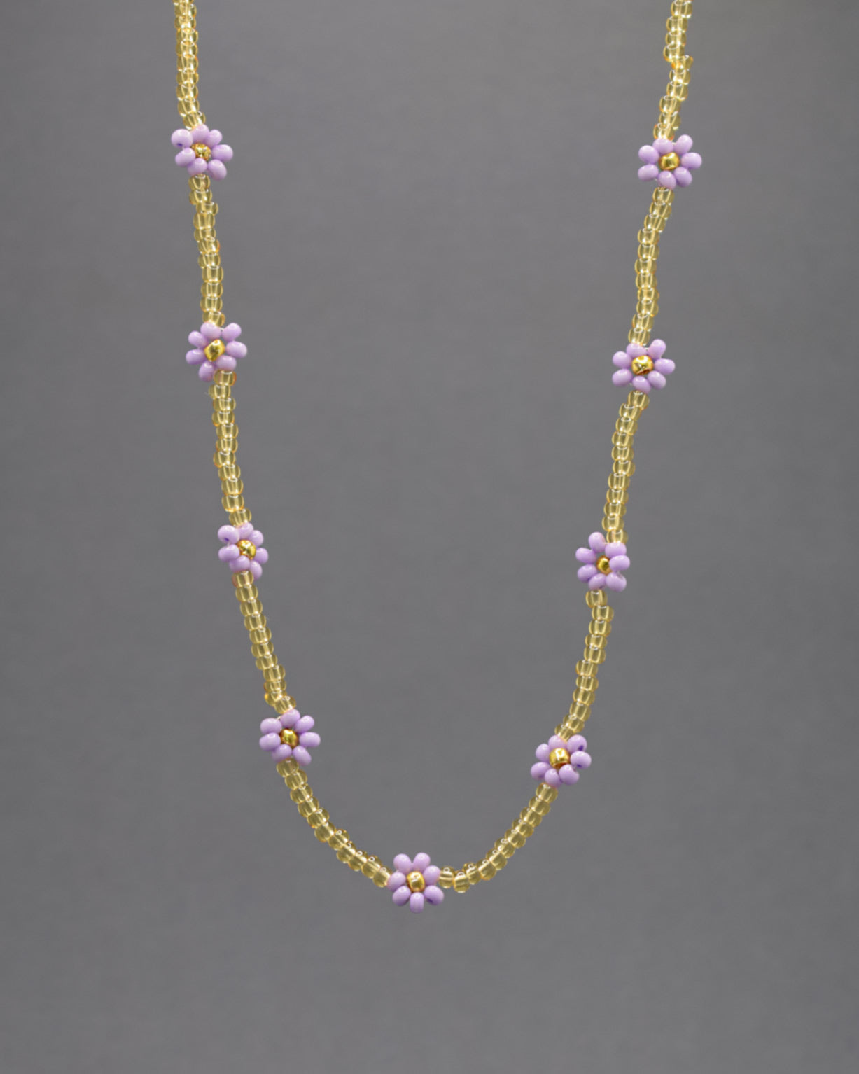 Adicione um toque de elegância e frescor ao seu visual com o nosso deslumbrante Colar de Missangas Douradas com Flores Roxas. Este colar exclusivo é artesanalmente confecionado com missangas de alta qualidade, formando um design harmonioso e delicado.