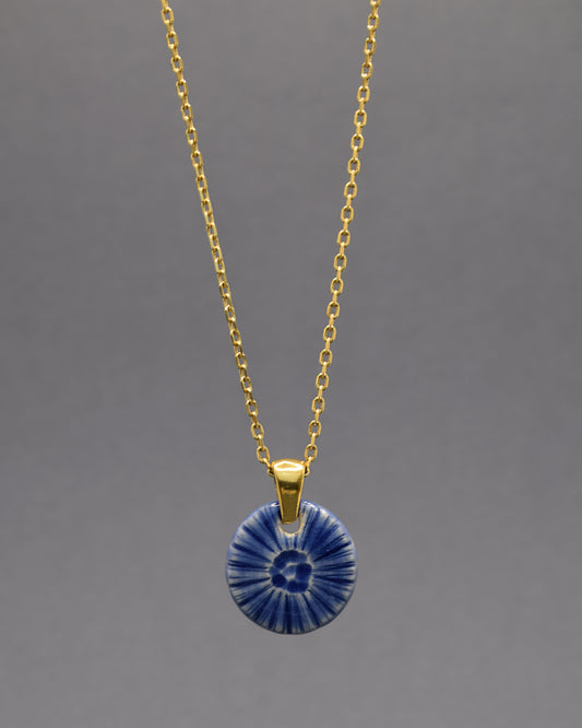 Colar artesanal em cerâmica azul escuro, inspirado na força do mar. Elegância contemporânea com acabamento único e orgânico.