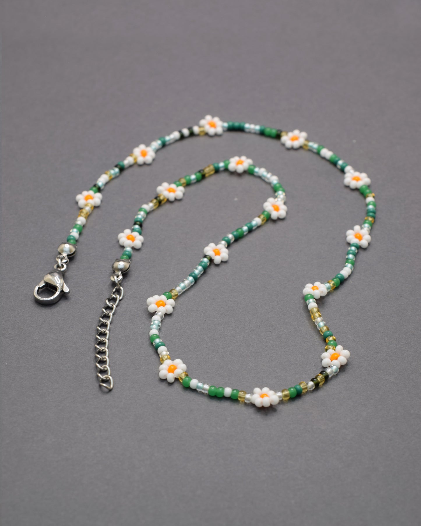 Colar com flores brancas e missangas mix em tons verdes, delicado e harmonioso, perfeito para um look fresco e natural.