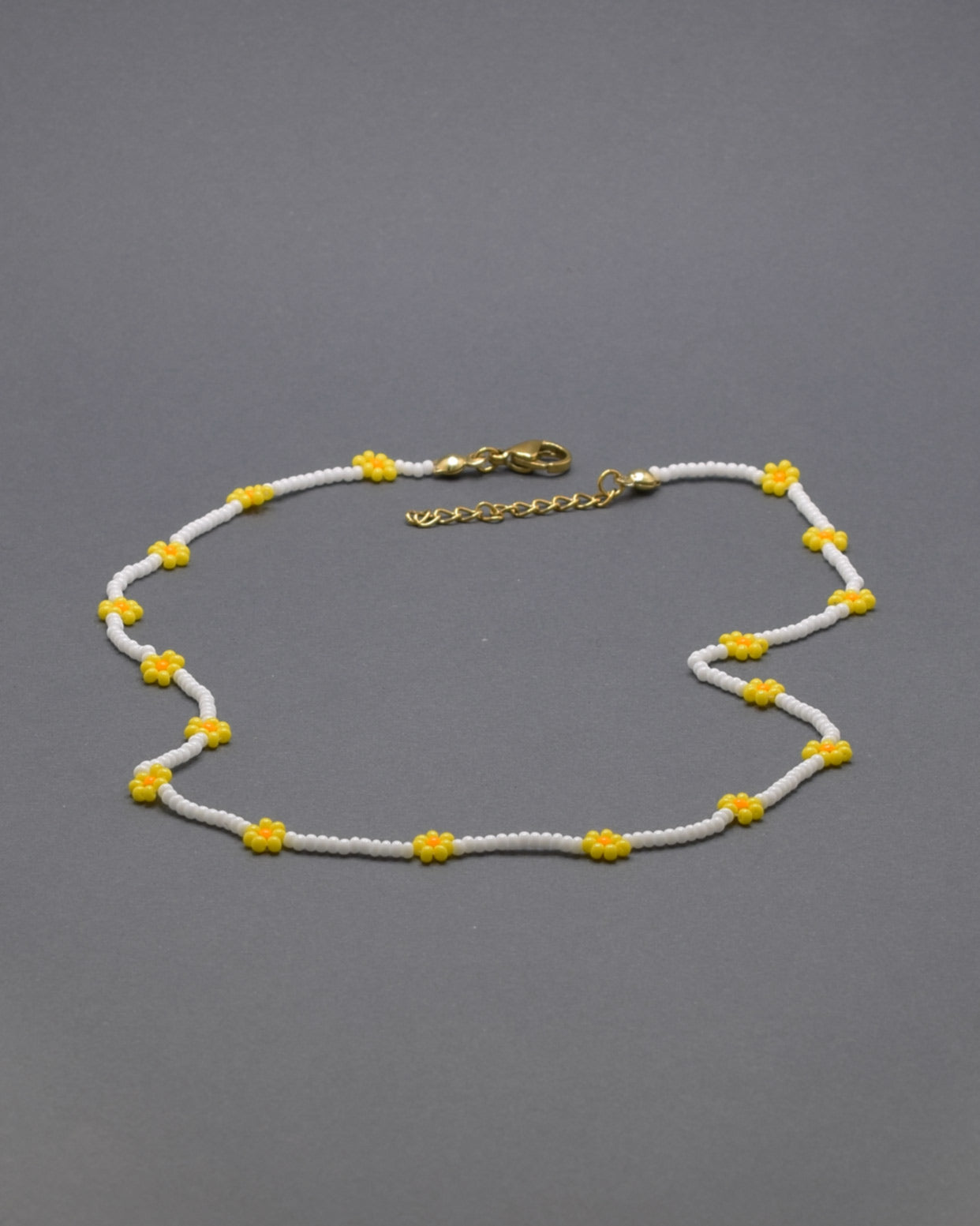 Adicione um toque de elegância e frescor ao seu visual com o nosso deslumbrante Colar de Missangas Brancas com Flores Amarelas. Este colar exclusivo é artesanalmente confecionado com missangas de alta qualidade, formando um design harmonioso e delicado.