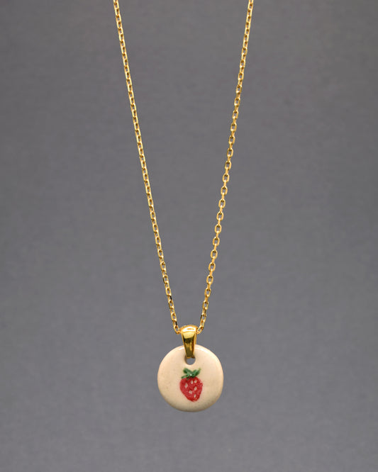 Evoque o glamour com nosso colar em aço inoxidável dourado, destacando um pendente gracioso com morango pintado à mão em cerâmica. A fusão de luxo e charme natural faz deste acessório uma declaração sofisticada, adicionando um toque de brilho e elegância ao seu estilo único.