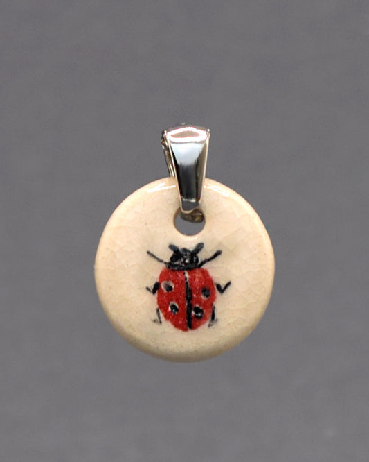 Pendente em cerâmica artesanal com joaninha pintada à mão, símbolo de sorte e alegria, ideal para quem aprecia detalhes únicos.