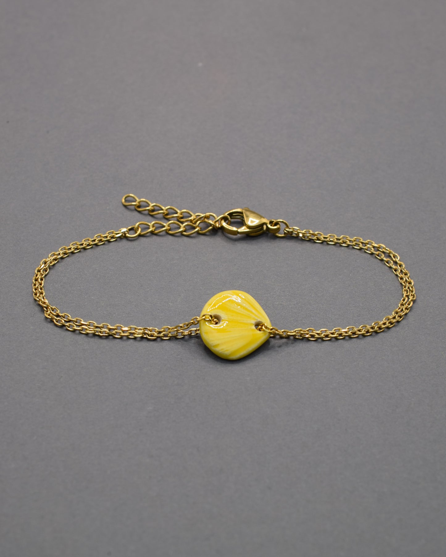 Pulseira com pendente de cerâmica em forma de concha amarela, leve e luminosa, perfeita para dar um toque solar e delicado ao teu estilo.