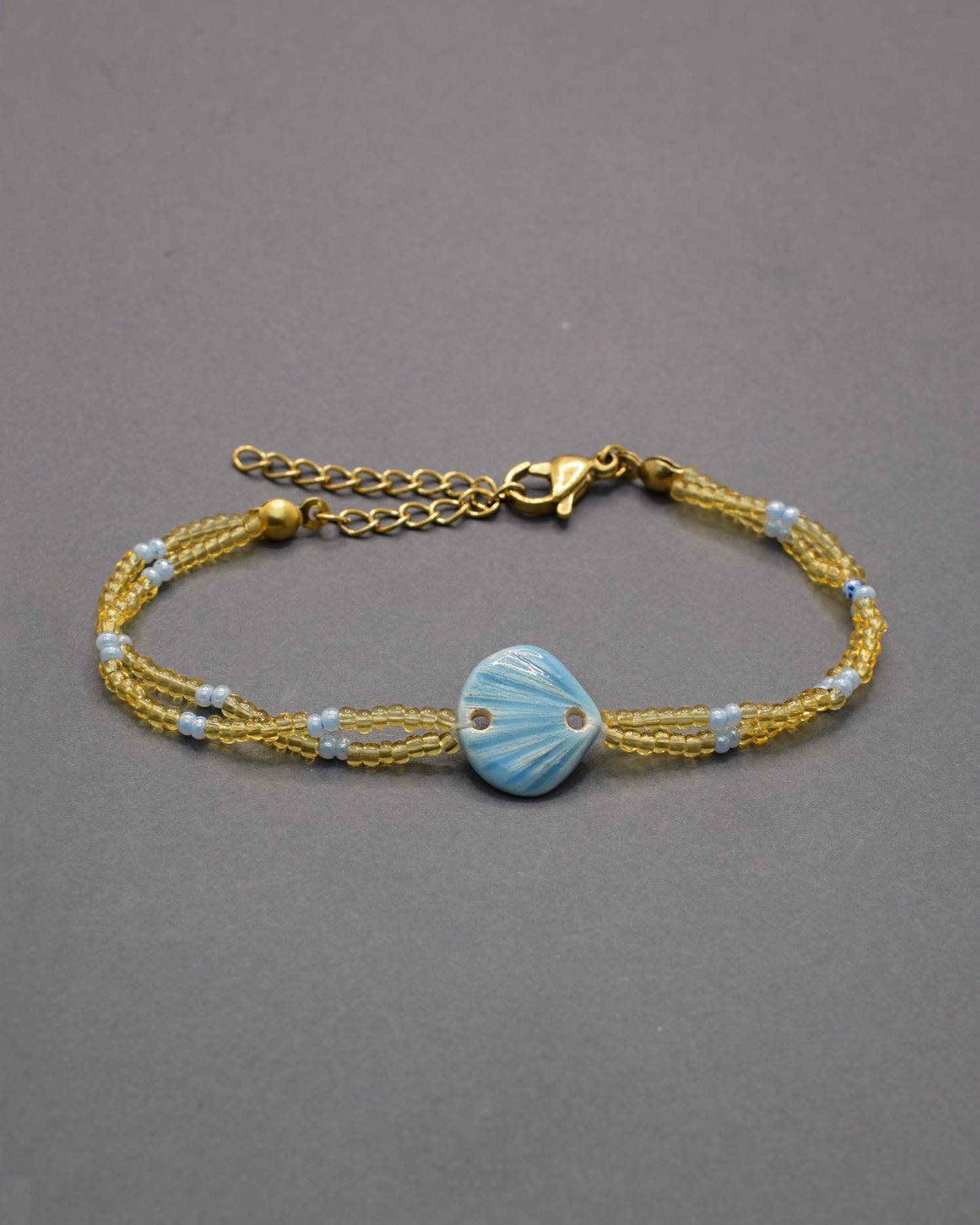 Pulseira Concha Azul Claro em cerâmica, delicada e fresca, perfeita para um toque leve e sereno que lembra o mar e os dias de verão.