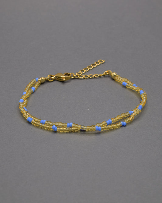 Pulseira dupla com missangas douradas semitransparentes e padrão azul neon. Design moderno e elegante para um look vibrante.