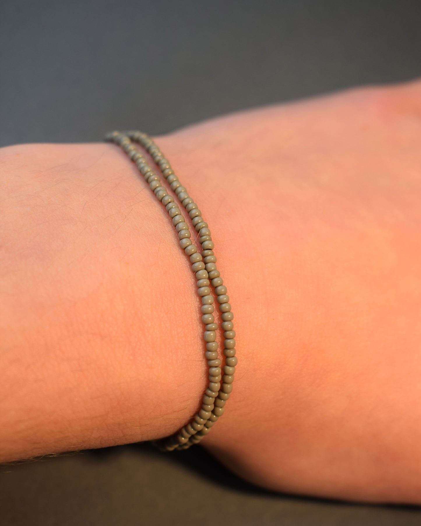 Pulseira dupla com missangas cinzentas. Design artesanal e elegante para um toque sofisticado no seu look.