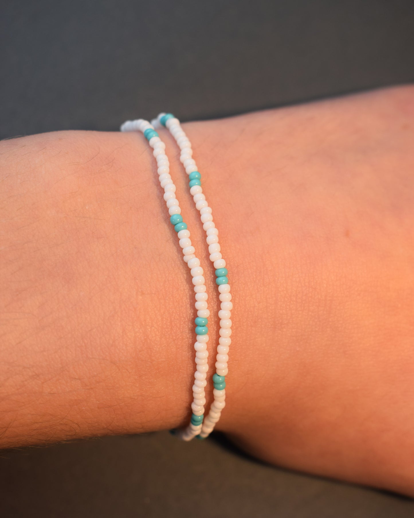 Pulseira dupla de missangas brancas com padrão turquesa. Estilo vibrante e único, perfeita para um look moderno e descontraído, cheio de cor e personalidade.