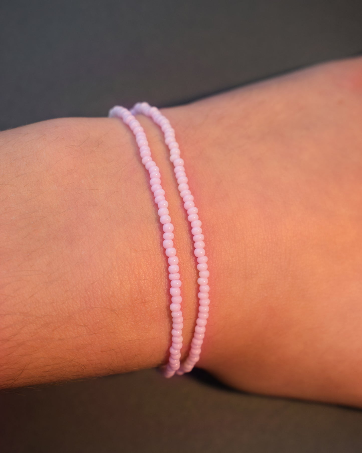 Pulseira dupla com missangas cor-de-rosa claro. Design artesanal e delicado para um look sofisticado.