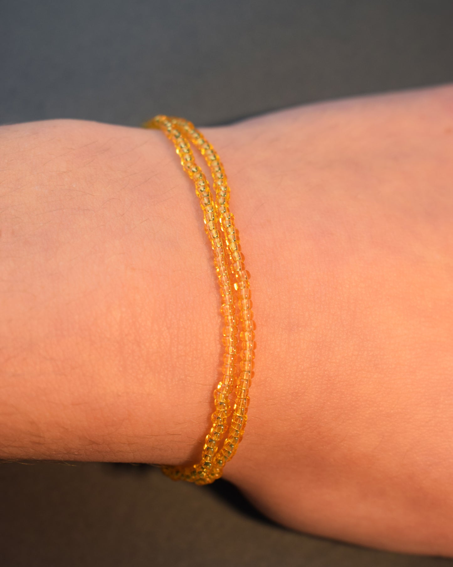 Pulseira dupla com missangas douradas semitransparentes. Elegância artesanal com brilho subtil, perfeita para um look sofisticado e intemporal.