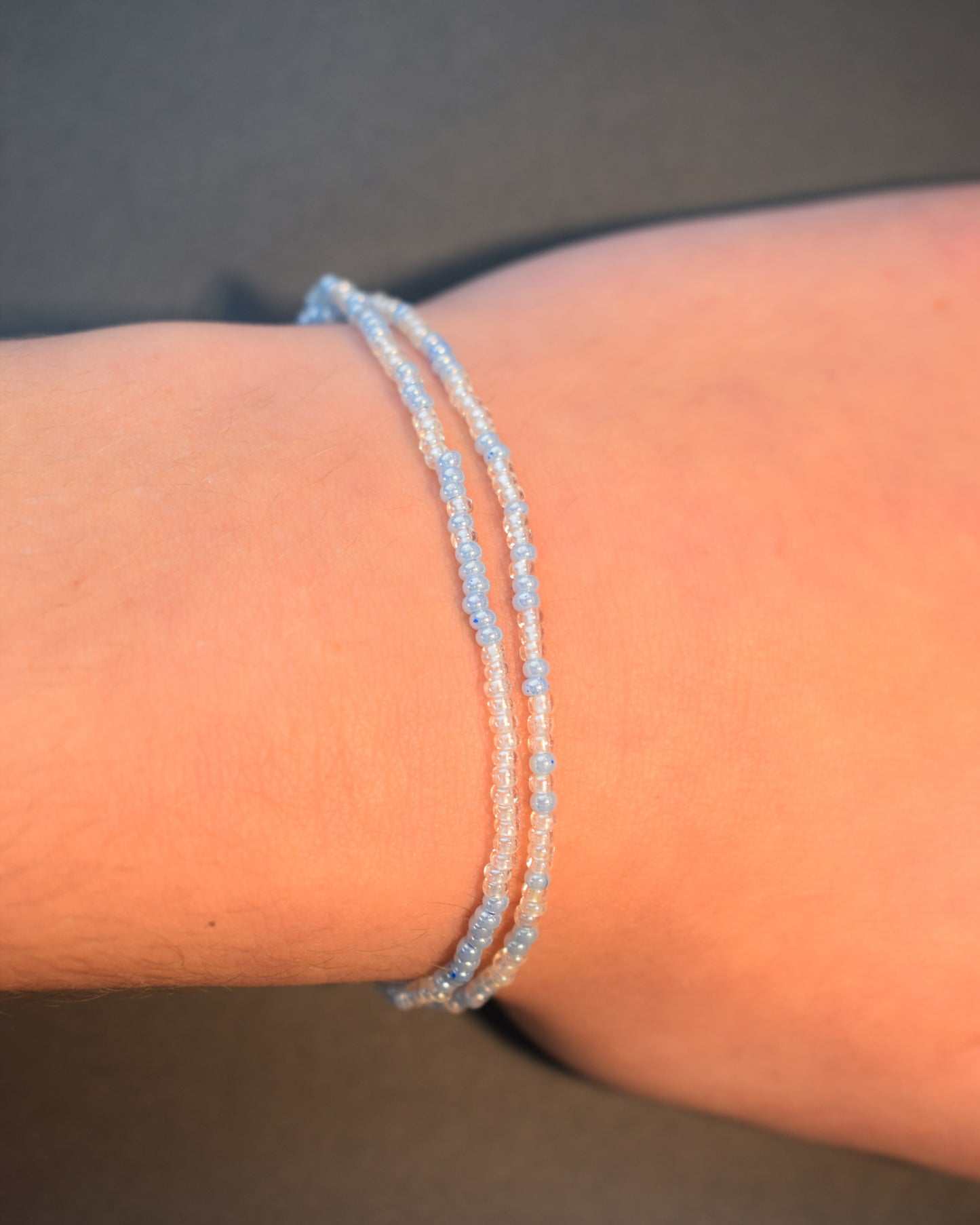 Pulseira dupla com missangas azul claro em mix suave. Peça artesanal e luminosa, ideal para complementar visuais leves e contemporâneos.