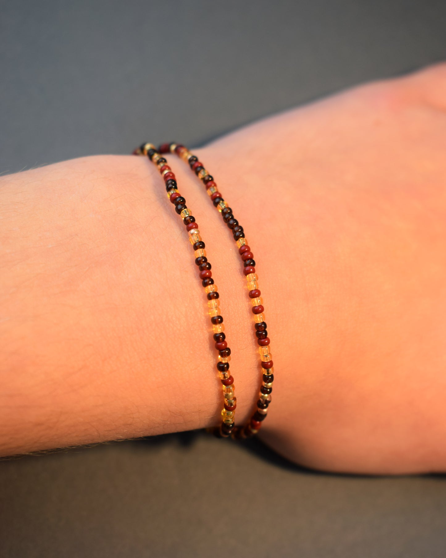 Pulseira dupla de missangas em mix bordô. Design artesanal sofisticado, ideal para um toque de cor elegante e versátil no teu look.