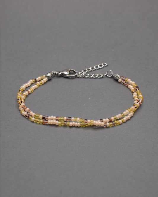 Pulseira dupla artesanal em mix dourado, combinando missangas luminosas para um look elegante e versátil, ideal para realçar qualquer estilo.