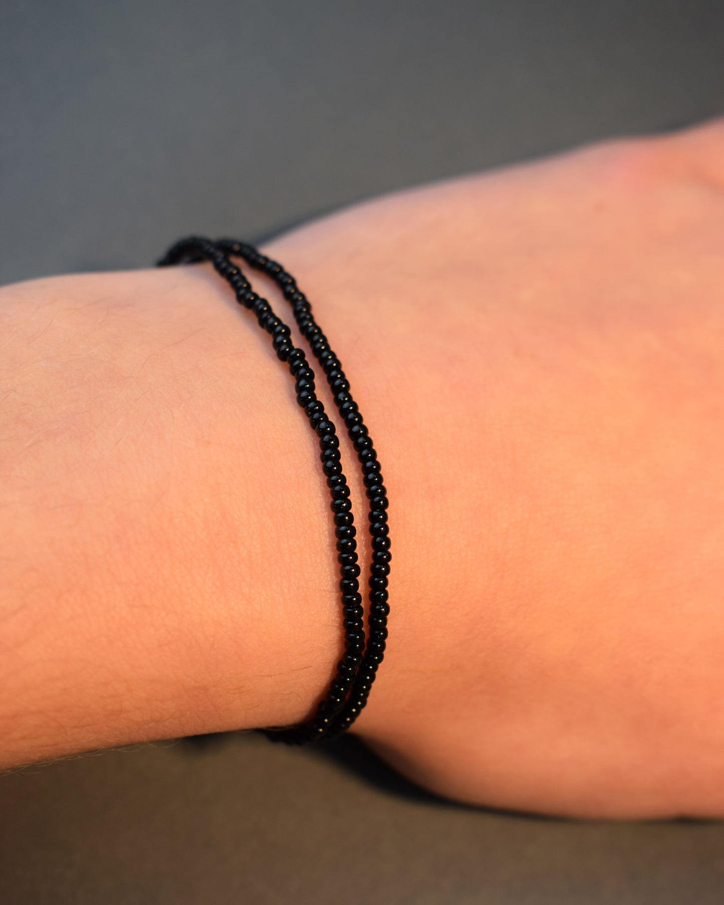 Pulseira dupla de missangas pretas, elegante e versátil, ideal para um look sofisticado e intemporal.