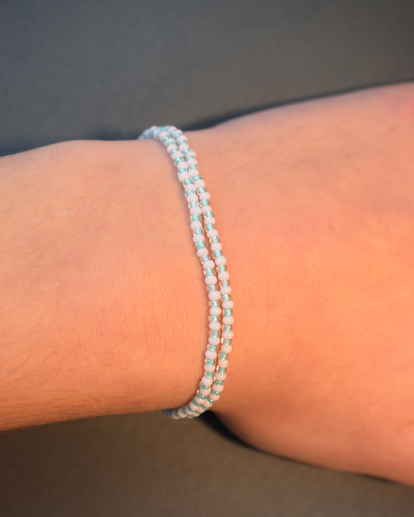 Pulseira dupla de missangas em rosa claro, com padrão verde claro semitransparente, num design delicado e harmonioso.