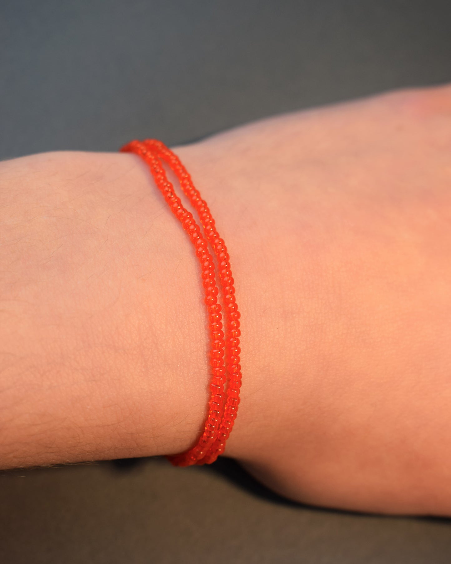 Pulseira dupla de missangas vermelhas alaranjadas semitransparentes. Design artesanal e vibrante, perfeita para adicionar um toque de cor e elegância ao seu look.