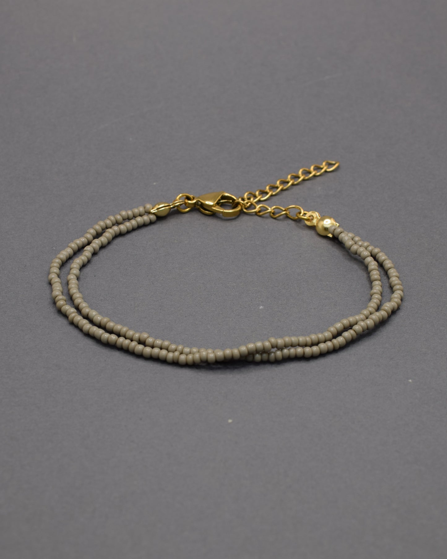 Pulseira dupla com missangas cinzentas. Design artesanal e elegante para um toque sofisticado no seu look.