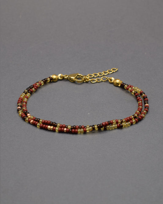 Pulseira dupla de missangas em mix bordô. Design artesanal sofisticado, ideal para um toque de cor elegante e versátil no teu look.