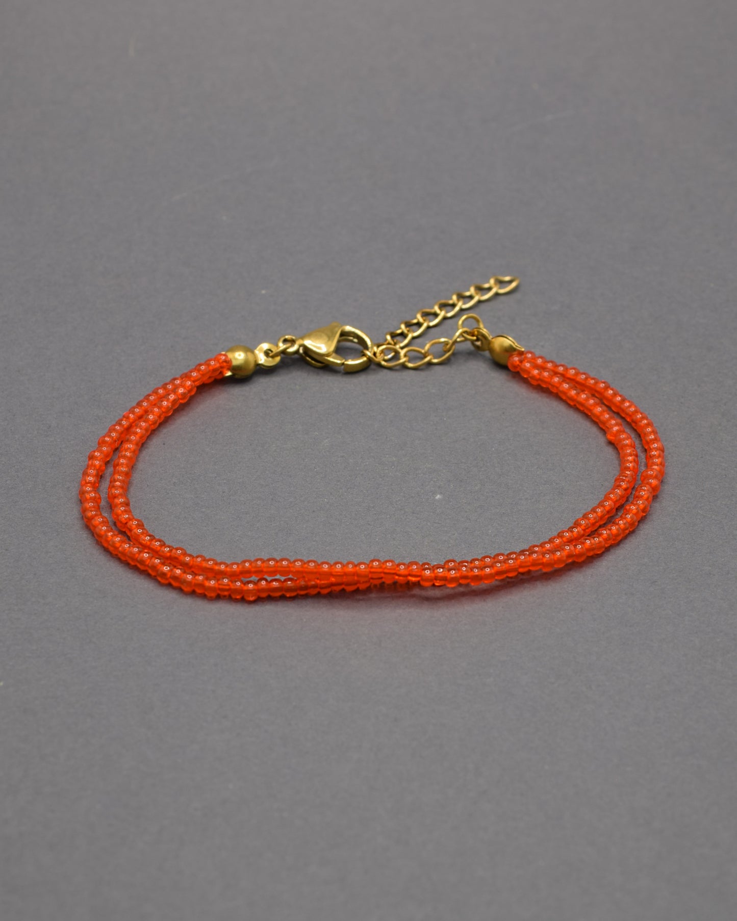 Pulseira dupla de missangas vermelhas-alaranjadas semitransparentes. Design artesanal e vibrante, perfeita para adicionar um toque de cor e elegância ao seu look.