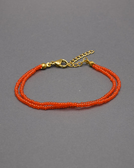 Pulseira dupla de missangas vermelhas-alaranjadas semitransparentes. Design artesanal e vibrante, perfeita para adicionar um toque de cor e elegância ao seu look.