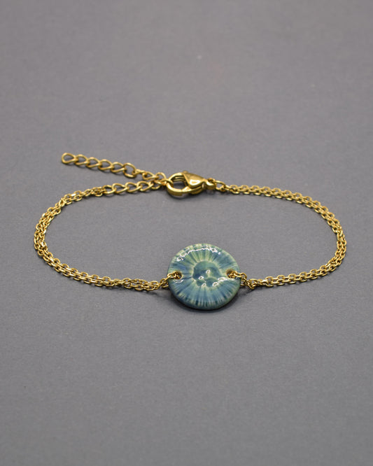 Pulseira delicada com pendente flor do mar em cerâmica verde musgo, inspirada na natureza e perfeita para um toque orgânico e sofisticado ao seu look.