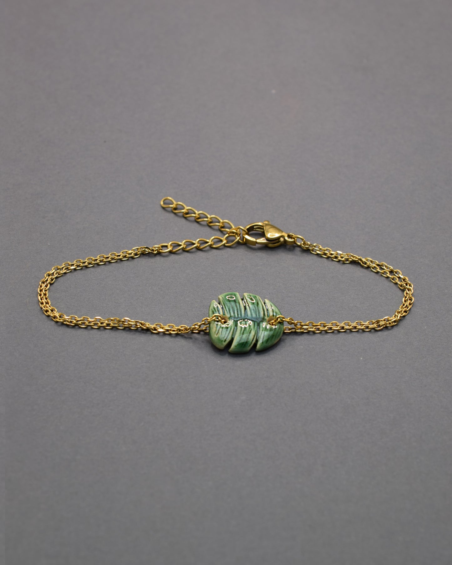 Pulseira delicada com pendente de folha verde em cerâmica, inspirada na natureza, leve e elegante para um toque fresco e sofisticado no seu dia a dia.