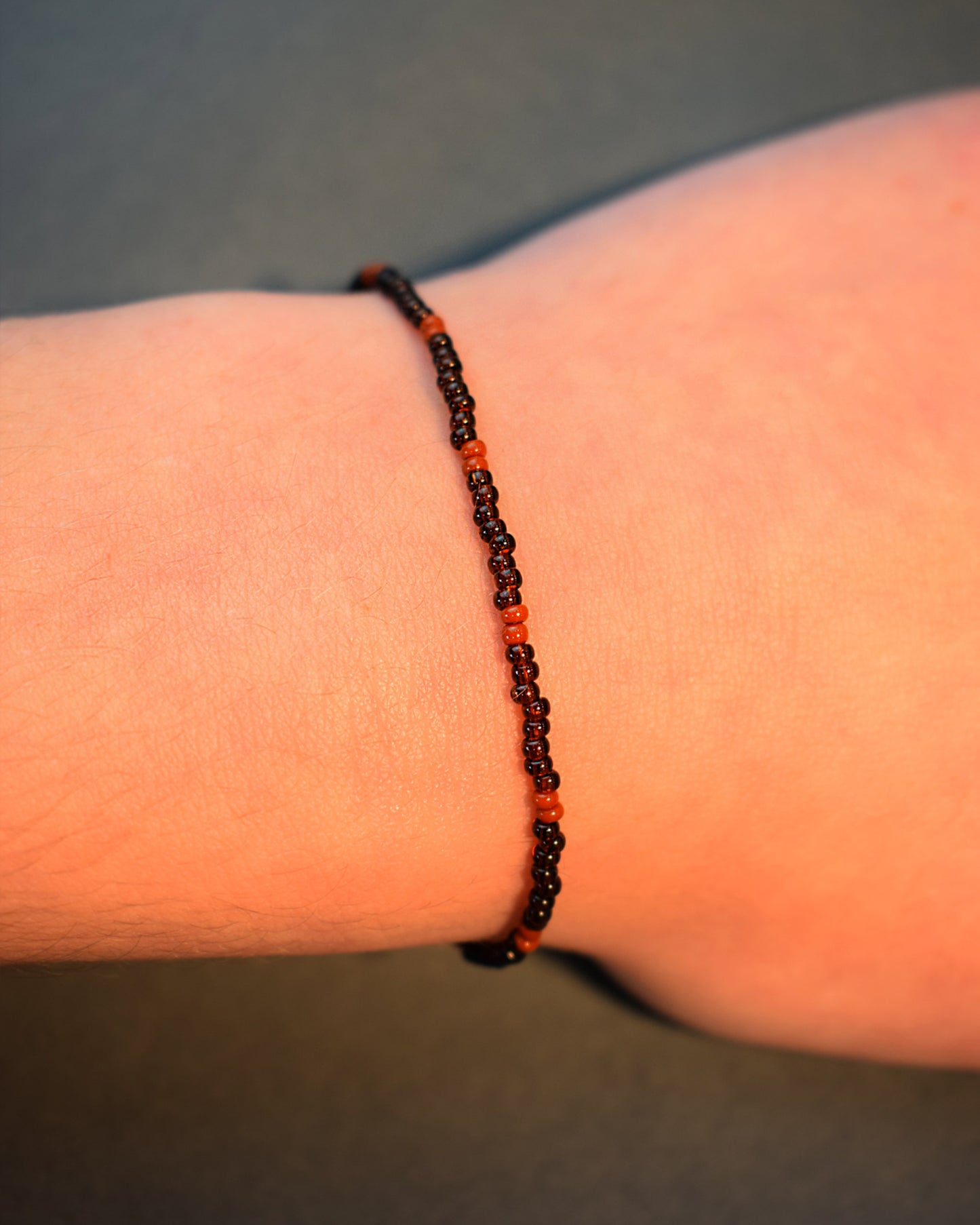 Pulseira de missangas castanhas semitransparentes com padrão castanho opaco. Elegante e versátil, ideal para um look natural e sofisticado.