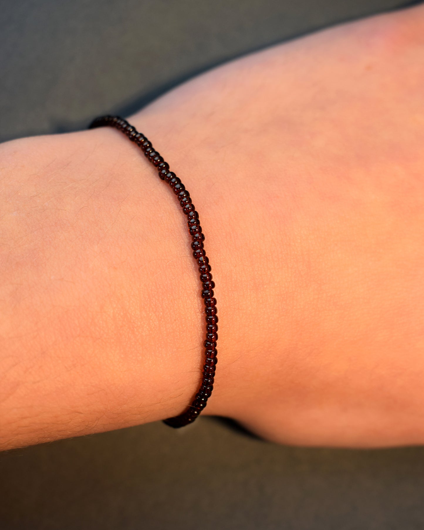 Pulseira com missangas castanhas semitransparentes. Design artesanal e elegante para um toque sofisticado no seu look.