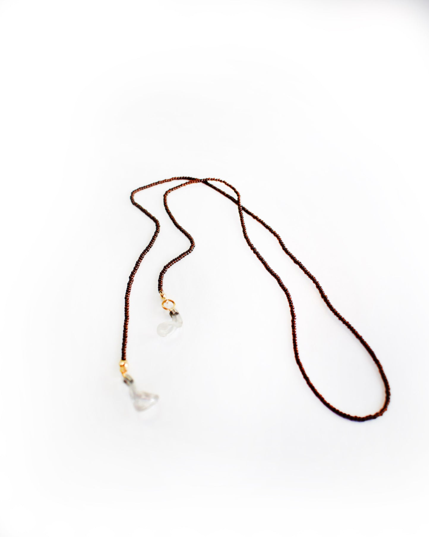 Acessórios de moda online - Corrente de óculos de cor castanha escura e missangas transparentes que quando refletida com a luz, retorna um bordô muito característico do tão apreciado suco das uvas fermentado, um requinte. Pode ainda combinar com as suas peças de bijuteria. Metal da bijuteria em aço inoxidável.