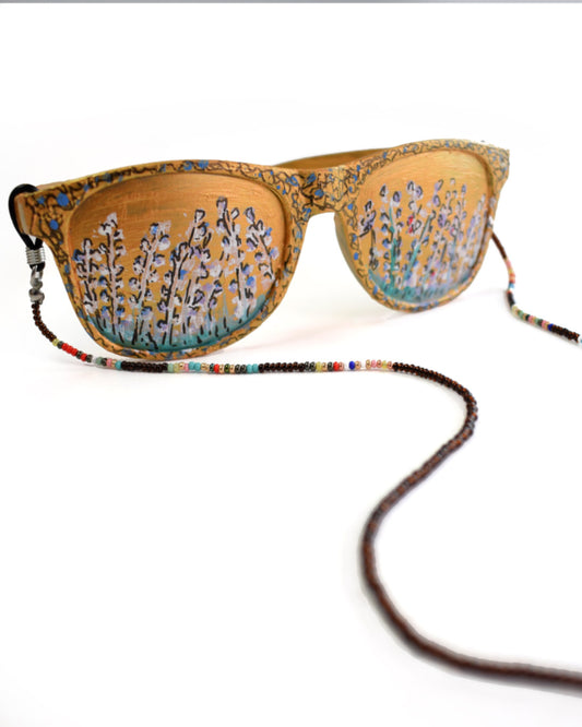 Acessórios de moda online - Corrente de óculos de missangas de cor castanha escura e transparentes que quando refletida a luz, retorna um bordô muito característico do tão apreciado suco das uvas fermentado, combinado com um colorido de missangas a dar um final de realce alegre para combinar com a sua bijuteria.