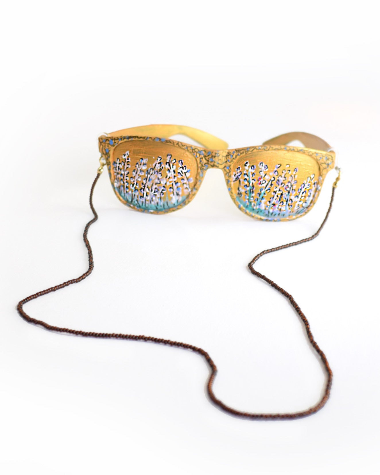 Acessórios de moda online - Corrente de óculos de cor castanha escura e missangas transparentes que quando refletida com a luz, retorna um bordô muito característico do tão apreciado suco das uvas fermentado, um requinte. Pode ainda combinar com as suas peças de bijuteria. Metal da bijuteria em aço inoxidável.
