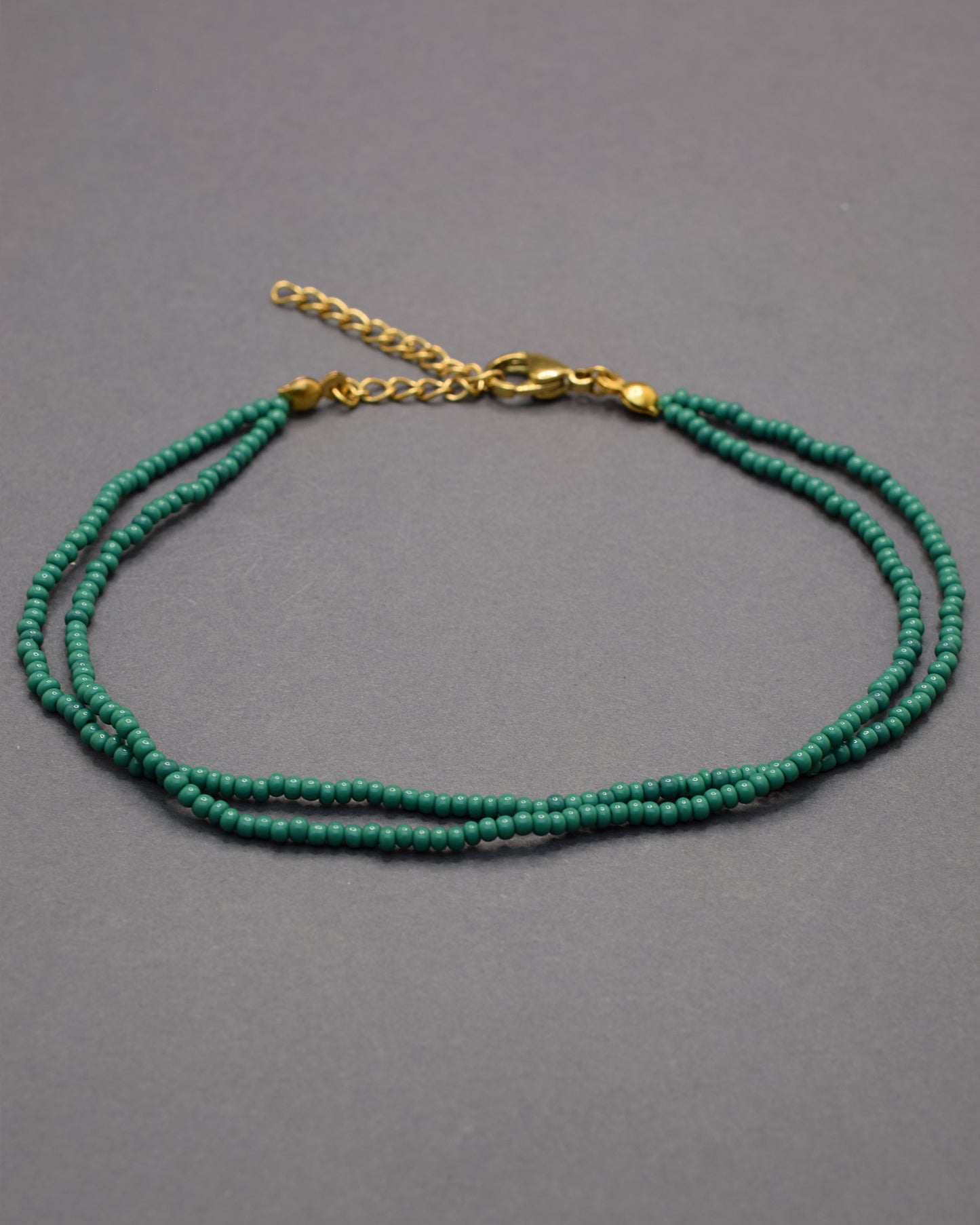 Pulseira dupla de tornozelo com missangas verdes, leve e vibrante, perfeita para um toque fresco e natural no teu estilo.