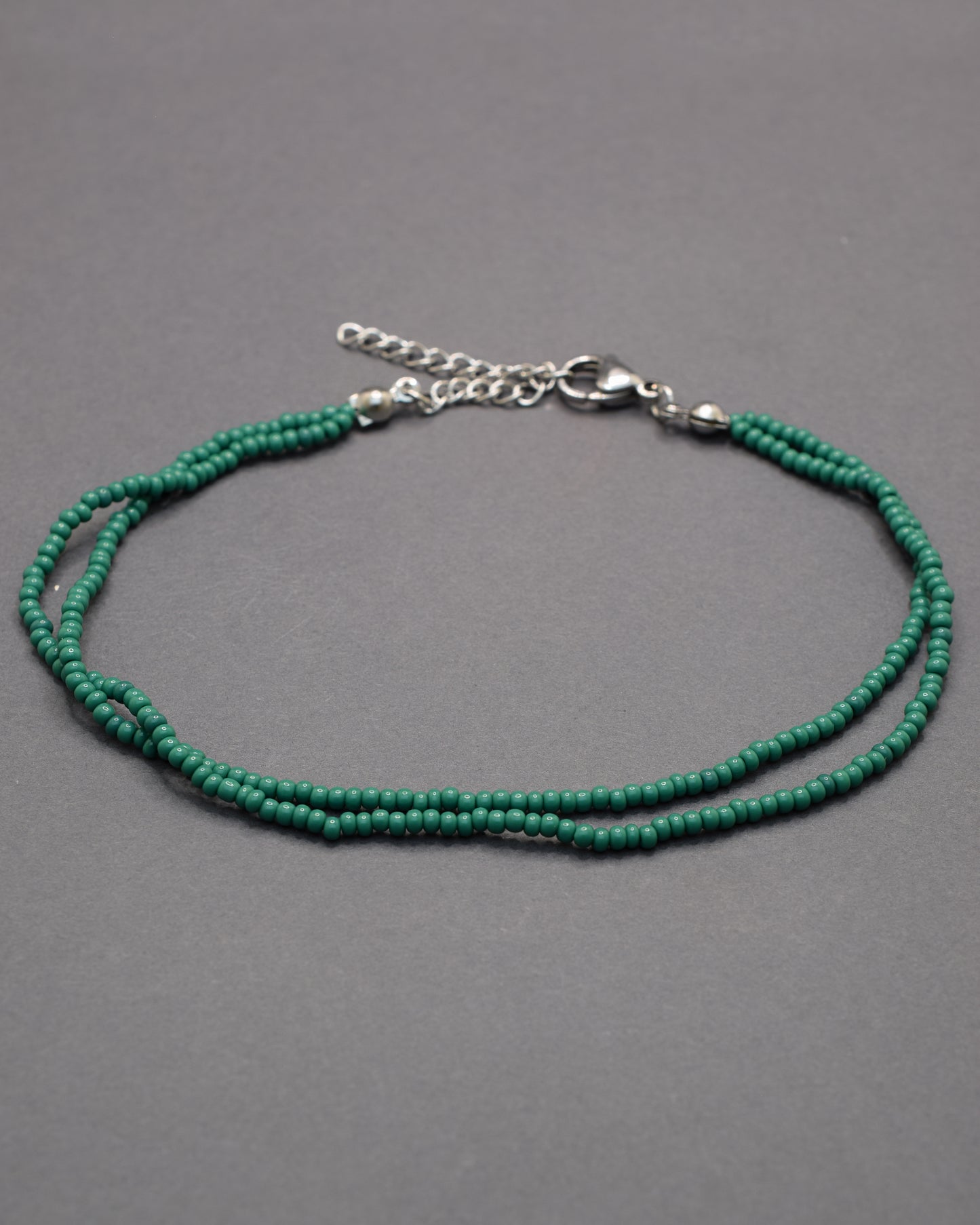 Pulseira dupla de tornozelo com missangas verdes, leve e vibrante, perfeita para um toque fresco e natural no teu estilo.